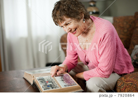 Senior woman looking at family album 7920864