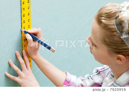 Woman measuring plywood and marking with pencil Woman measuring plywood and marking with pencil 7920959