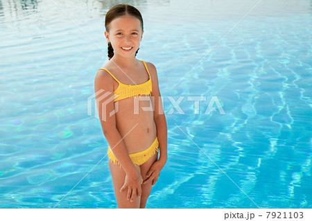 Girl in yellow bikini by swimming pool, portrait Girl in yellow bikini by swimming pool, portrait 7921103