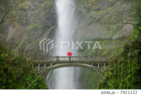 Woman with red umbrella in front of Multnomah Falls, Columbia River Gorge, USA 7921122