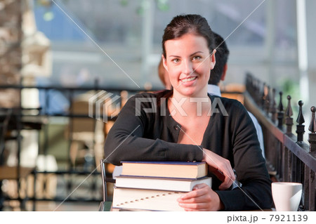 Young student leaning on stack of books, portrait Young student leaning on stack of books, portrait 7921139