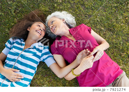 Grandmother and granddaughter lying on grass Grandmother and granddaughter lying on grass 7921274
