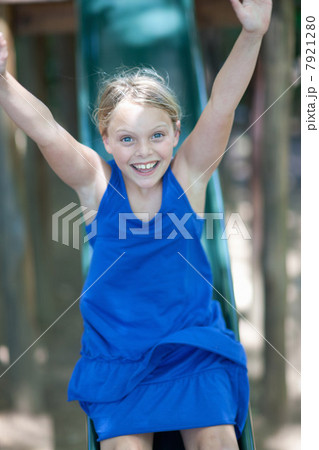Girl playing on slide outdoors Girl playing on slide outdoors 7921280