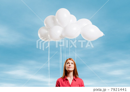 Young woman looking at thought bubble made of balloons 7921441