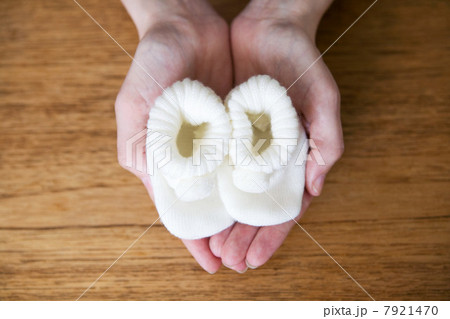 Pregnant woman holding baby booties Pregnant woman holding baby booties 7921470