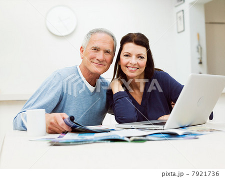 Mature couple using laptop to book vacation 7921736