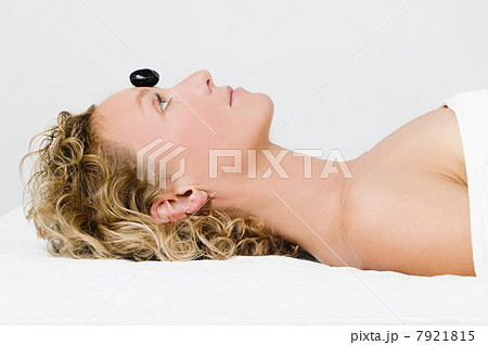 Young woman having hot stone therapy 7921815
