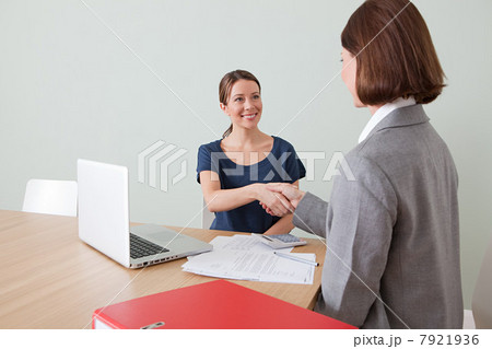 Young woman shaking hands with financial adviser 7921936