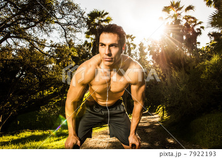 Young man exercising in forest resting 7922193