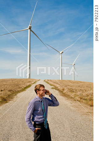 Man using mobile phone in front of wind turbines Man using mobile phone in front of wind turbines 7922213