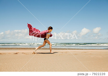 Girl running with blanket at beach 7922220