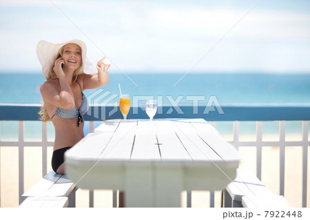 Woman on cell phone at table on deck 7922448