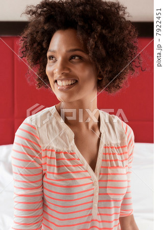 Smiling woman sitting on bed 7922451