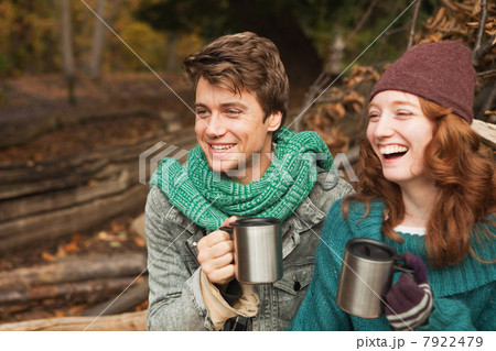 Young couple in forest holding flasks Young couple in forest holding flasks 7922479