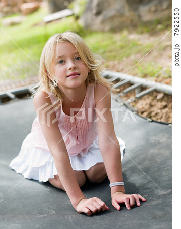 Girl kneeling on trampoline 7922550