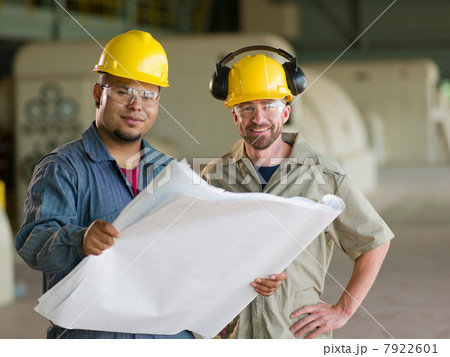 Engineers reading blueprints on site Engineers reading blueprints on site 7922601
