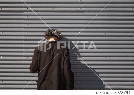 Senior man facing wall with head downturned Senior man facing wall with head downturned 7922791