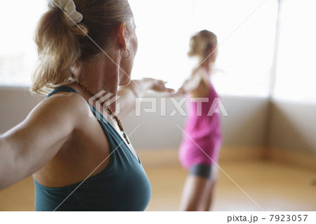 Mature female with outstretched arms in exercise class 7923057