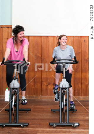 Two women on exercise bikes Two women on exercise bikes 7923202