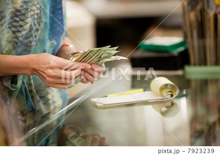 Shop keeper counting money in shop Shop keeper counting money in shop 7923239