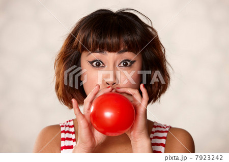 Woman blowing up balloon 7923242