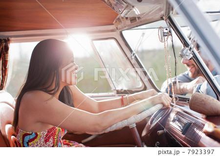 Young woman in camper van and smiling at boyfriend 7923397