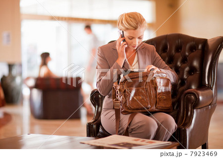 Businesswoman on cell phone in lobby Businesswoman on cell phone in lobby 7923469