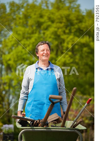 Man pushing wheelbarrow in plant nursery Man pushing wheelbarrow in plant nursery 7923561