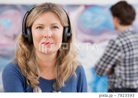 Mid adult woman wearing headphones in gallery 7923593