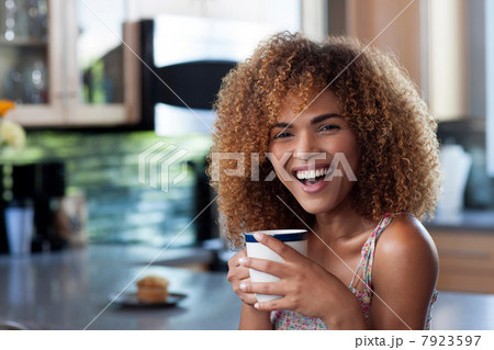 Mid adult woman enjoying coffee in kitchen, portrait 7923597