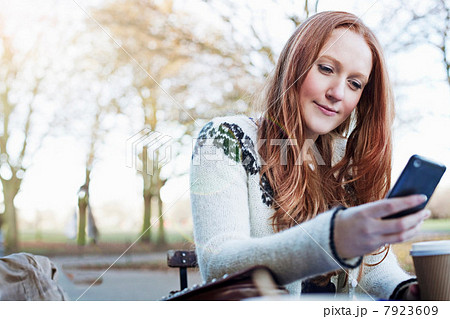 Woman using cell phone outdoors 7923609