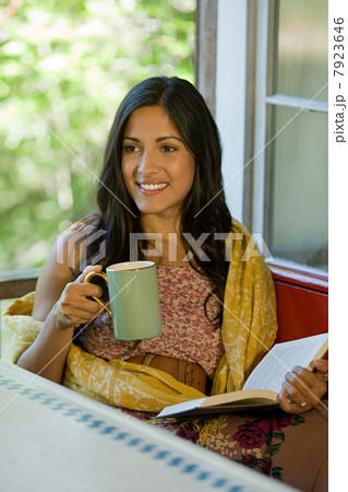 Woman relaxing with a drink and a book 7923646