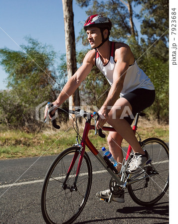 Young man cycling on road Young man cycling on road 7923684