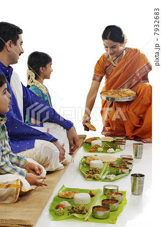 South Indian woman serving food to her family 7932683
