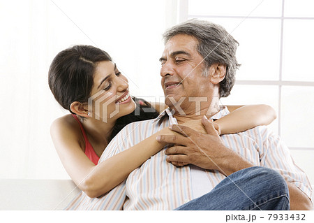 Girl with her arms around her father 7933432