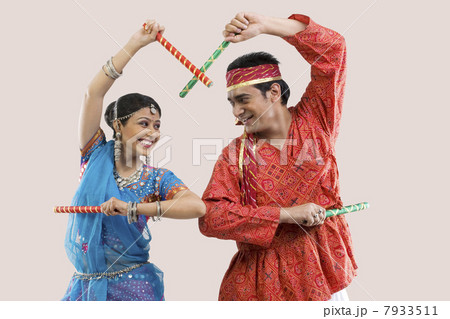 Gujarati couple performing dandiya Gujarati couple performing dandiya 7933511