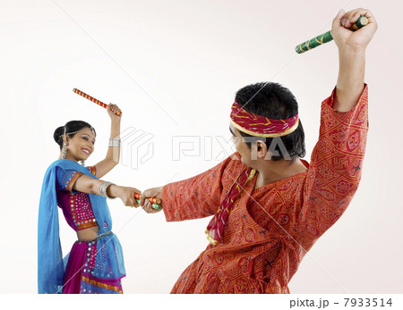 Gujarati couple performing dandiya Gujarati couple performing dandiya 7933514