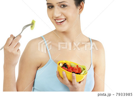 Woman eating fruits from a bowl 7933985