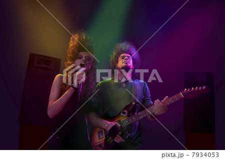 Woman singing while man plays on the guitar 7934053