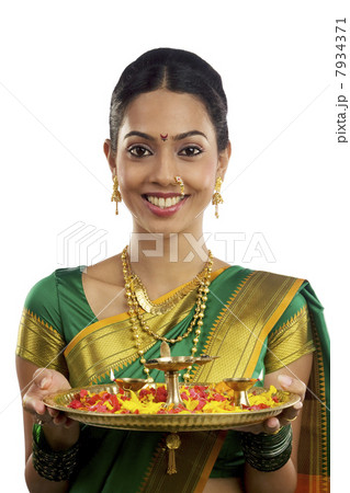 Portrait of a woman holding a tray with diyas 7934371