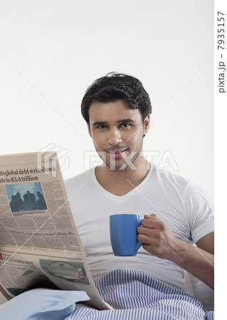 Man with a newspaper and coffee 7935157