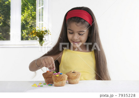 Girl decorating muffins 7935228