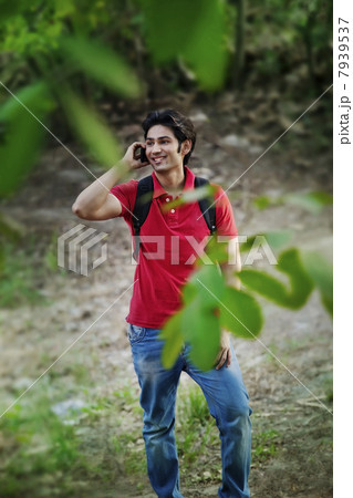 Young man talking on mobile phone and looking away 7939537