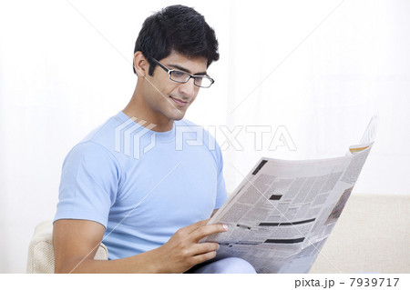 Young Indian man reading global news at home 7939717