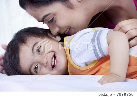 Mother and son smiling on a bed 7939856