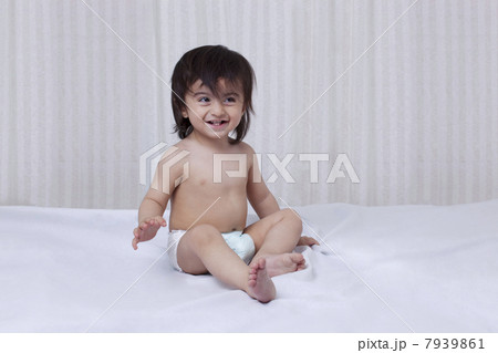 Little boy sitting on a bed 7939861