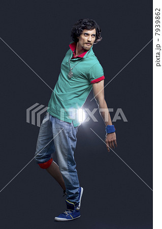 Full length of young Indian man dancing against black background 7939862