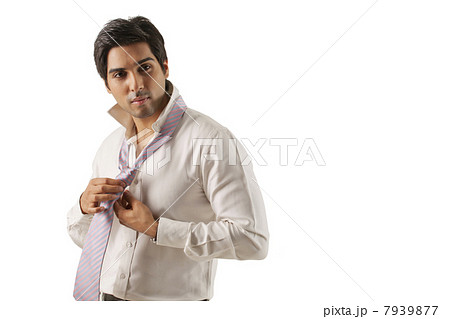 Confident young man tying his tie 7939877