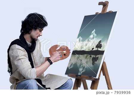 Young artist painting against colored background 7939936