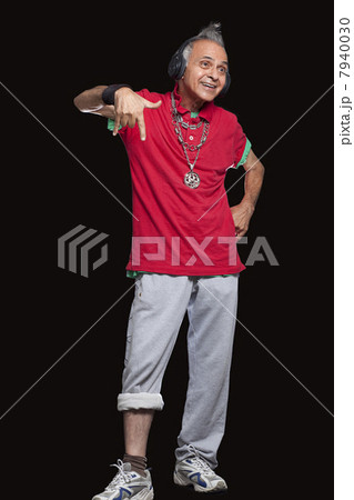 Smiling senior man gesturing over black background 7940030